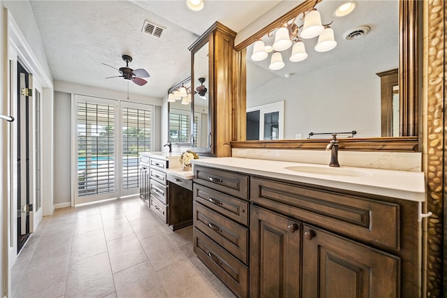 bathroom with ceiling fan, tile patterned floors, a textured ceiling, lofted ceiling, and vanity