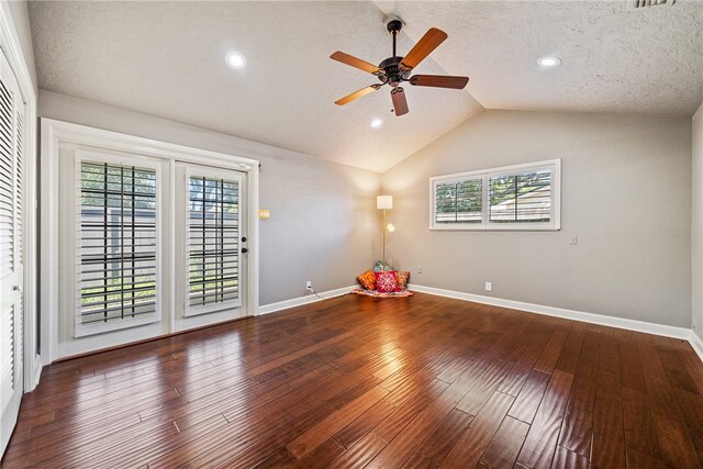 empty room featuring a wealth of natural light, ceiling fan, hardwood / wood-style floors, and lofted ceiling