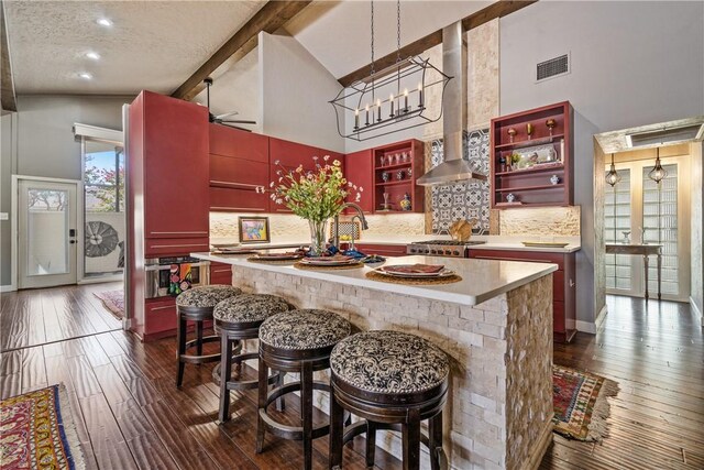 kitchen featuring a kitchen breakfast bar, backsplash, and high vaulted ceiling