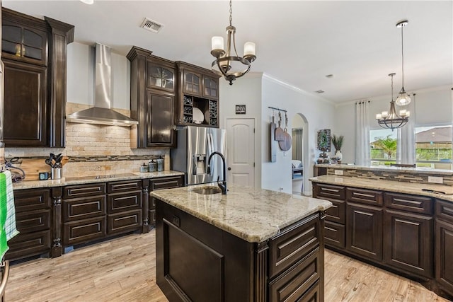 kitchen featuring an inviting chandelier, wall chimney exhaust hood, visible vents, and stainless steel refrigerator with ice dispenser