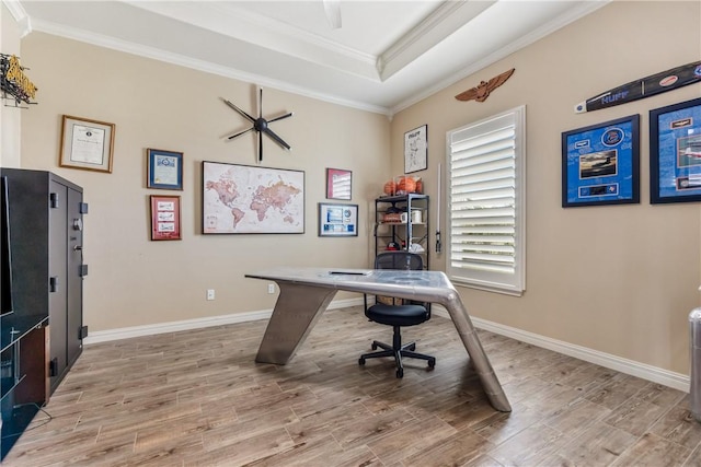 home office with baseboards, a tray ceiling, wood finished floors, and ornamental molding