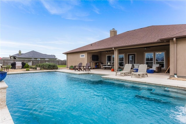 view of swimming pool with a patio area, ceiling fan, fence, and a fenced in pool