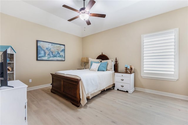 bedroom featuring a ceiling fan, lofted ceiling, baseboards, and light wood finished floors