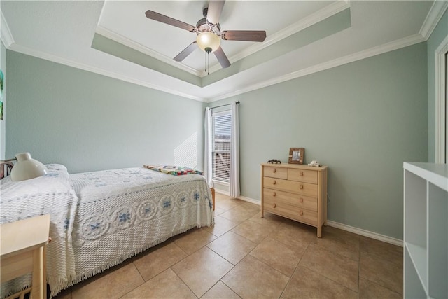 bedroom featuring light tile patterned floors, a tray ceiling, ornamental molding, and ceiling fan