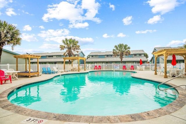 community pool with a patio area, fence, and a pergola