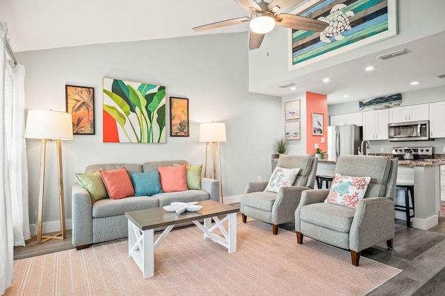 living area with light wood-style floors, baseboards, visible vents, and ceiling fan