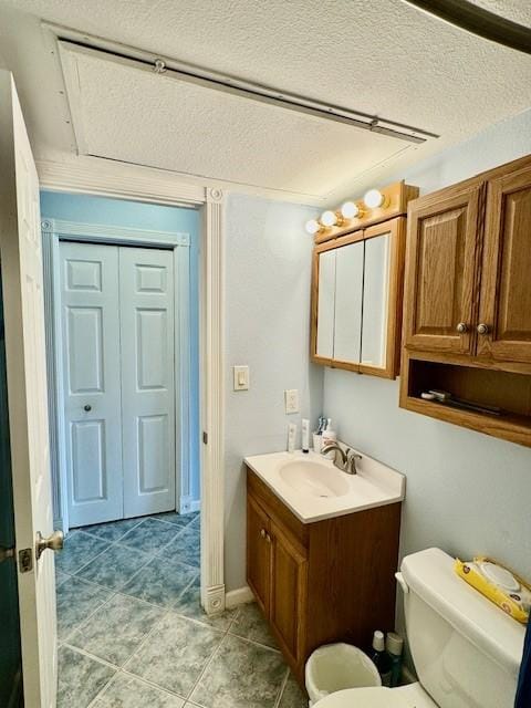 bathroom featuring vanity, a textured ceiling, and toilet