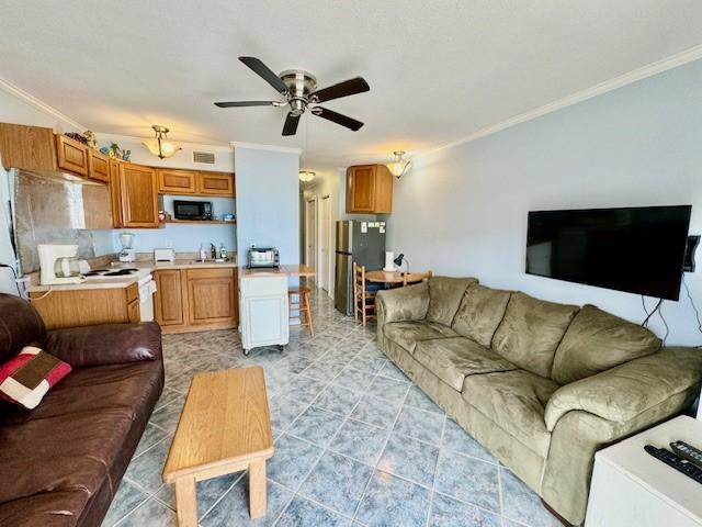 living room with sink, crown molding, and ceiling fan