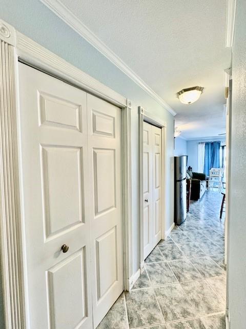 hall featuring crown molding and a textured ceiling