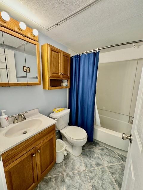 full bathroom with vanity, shower / bath combination with curtain, a textured ceiling, and toilet