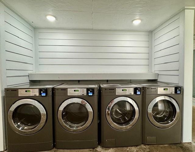 laundry area with washer and dryer and wood walls