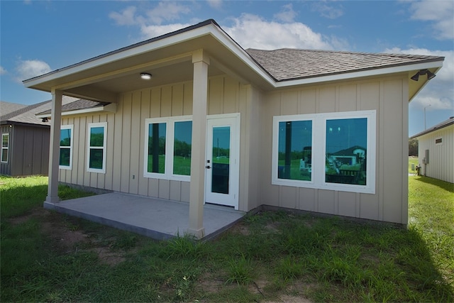 3629 Rebecca Dr, Corpus Christi, TX 78410 - back of property with a patio area, a shingled roof, board and batten siding, and a yard