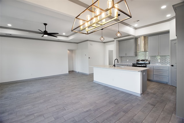 3629 Rebecca Dr, Corpus Christi, TX 78410 - kitchen with electric range, gray cabinets, a raised ceiling, ornamental molding, and wall chimney range hood