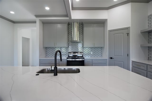 3629 Rebecca Dr, Corpus Christi, TX 78410 - kitchen with gray cabinetry, wall chimney range hood, stainless steel range with electric stovetop, crown molding, and decorative backsplash