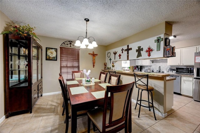 dining area with light tile patterned floors, a textured ceiling, baseboards, and an inviting chandelier