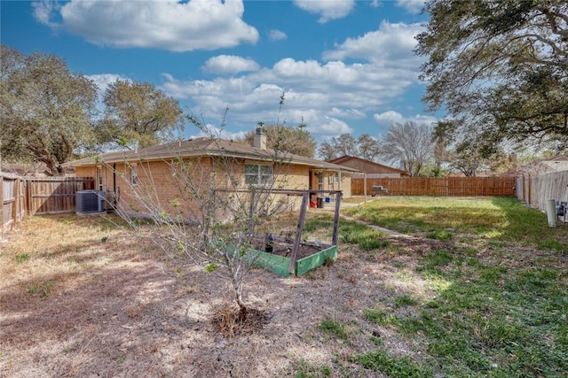 view of yard featuring cooling unit, a fenced backyard, and a vegetable garden