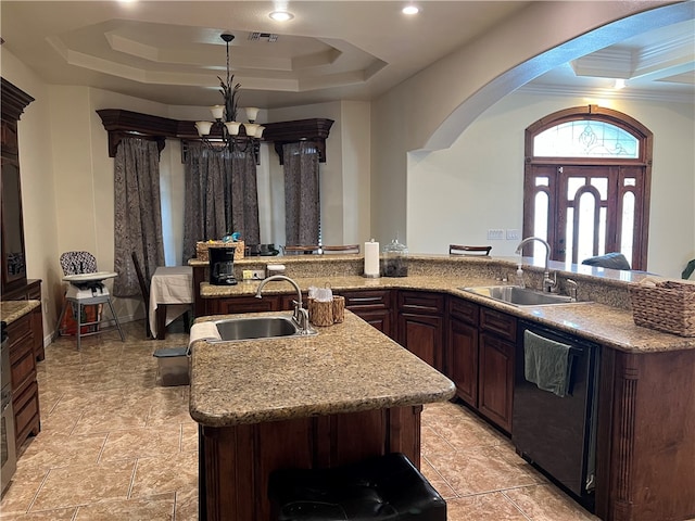 kitchen featuring an inviting chandelier, sink, a kitchen island with sink, and black dishwasher