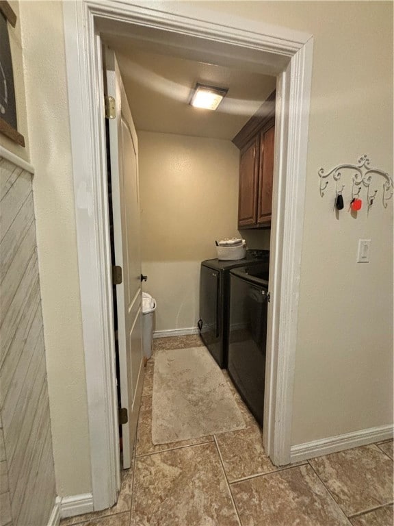 laundry area with cabinets, washing machine and dryer, and light tile patterned floors