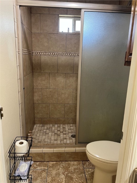 bathroom featuring toilet, tile patterned flooring, and walk in shower