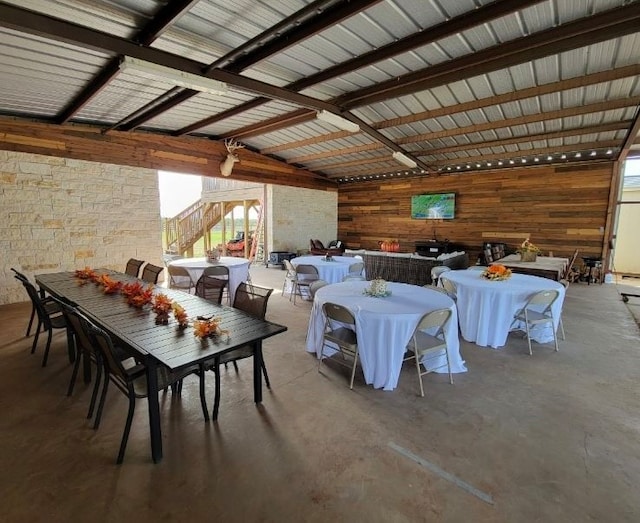 dining area featuring beamed ceiling and concrete floors