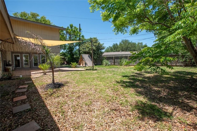 view of yard featuring french doors, a patio area, and a fenced backyard