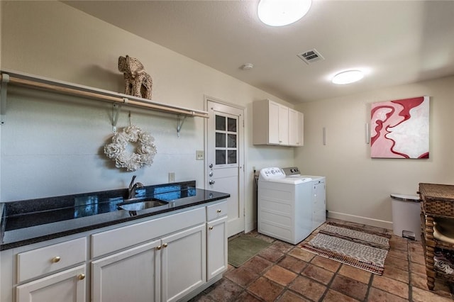 clothes washing area featuring a sink, separate washer and dryer, cabinet space, baseboards, and visible vents