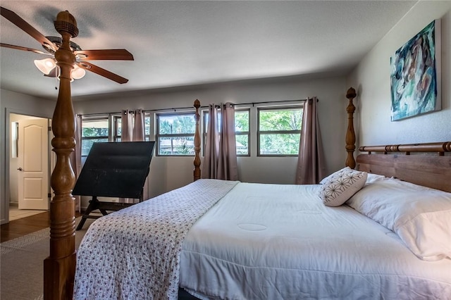 bedroom with wood finished floors, ceiling fan, and multiple windows