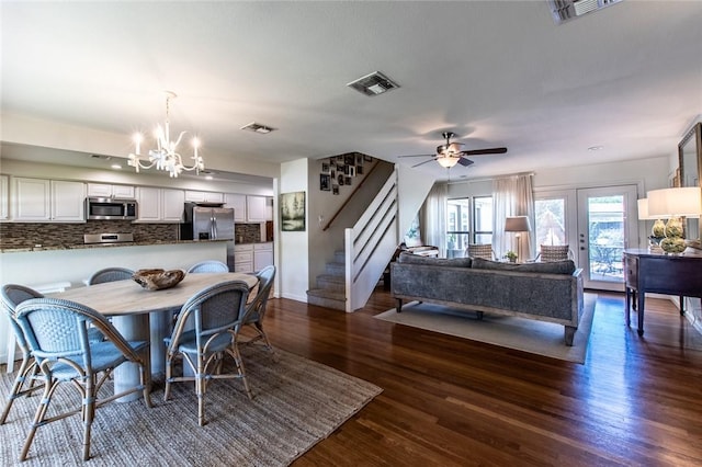 dining space featuring dark wood-type flooring, visible vents, and stairs