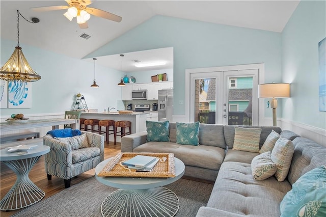 living room featuring vaulted ceiling, hardwood / wood-style flooring, and ceiling fan