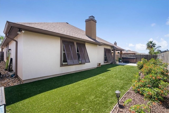 15825 Cozumel Dr, Corpus Christi, TX 78418 - rear view of house with a hot tub, a fenced backyard, stucco siding, and a chimney