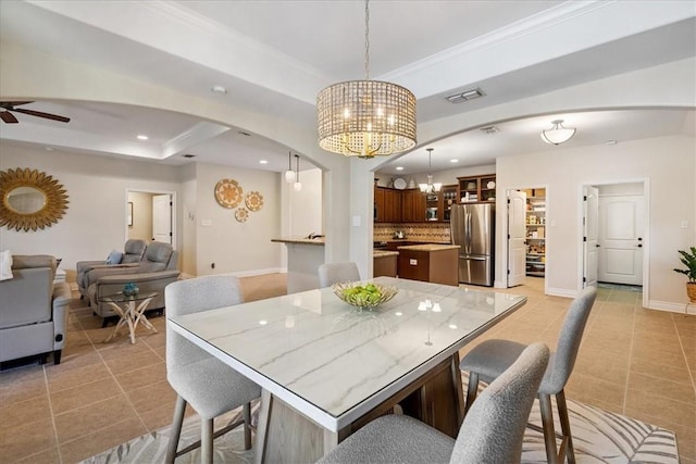 15825 Cozumel Dr, Corpus Christi, TX 78418 - dining area featuring arched walkways, light tile patterned floors, a chandelier, a raised ceiling, and recessed lighting