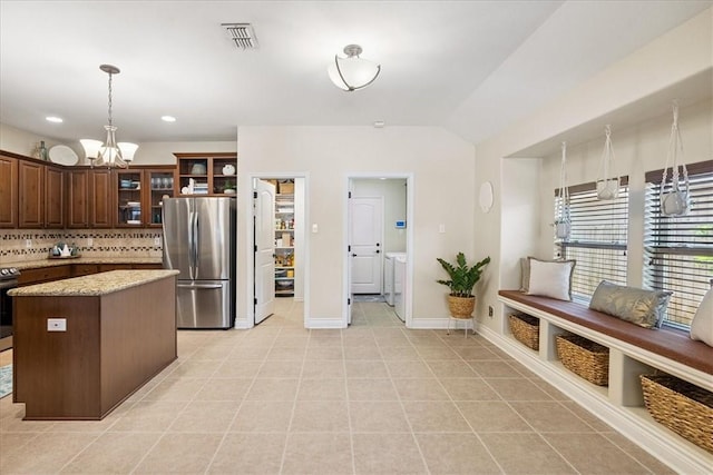 15825 Cozumel Dr, Corpus Christi, TX 78418 - kitchen with freestanding refrigerator, a chandelier, pendant lighting, a kitchen island, and glass insert cabinets