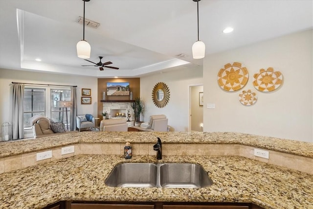 15825 Cozumel Dr, Corpus Christi, TX 78418 - kitchen with a tray ceiling, a ceiling fan, light stone countertops, open floor plan, and recessed lighting