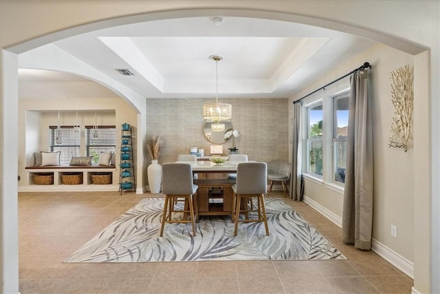 15825 Cozumel Dr, Corpus Christi, TX 78418 - dining area featuring tile patterned flooring, a chandelier, arched walkways, and a raised ceiling