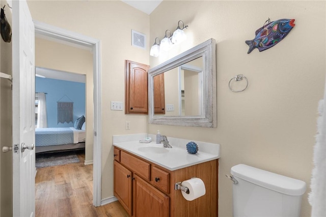 bathroom with vanity, hardwood / wood-style flooring, and toilet