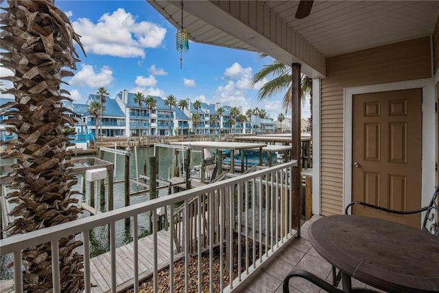 balcony featuring a water view and ceiling fan