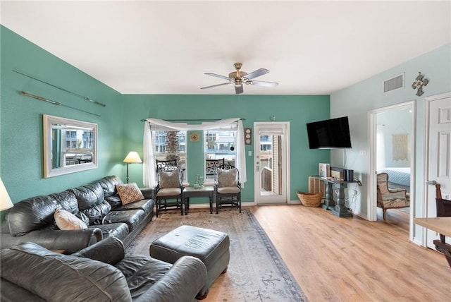 living room featuring ceiling fan and light wood-type flooring