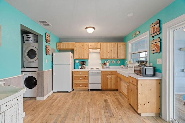 kitchen featuring light countertops, visible vents, stacked washer / dryer, white appliances, and under cabinet range hood