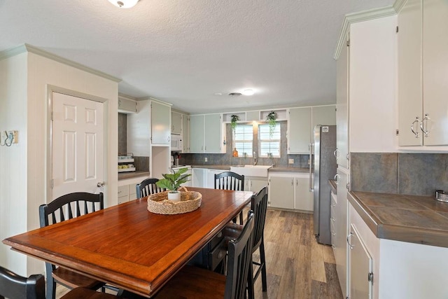 dining area with light wood-style flooring and a textured ceiling