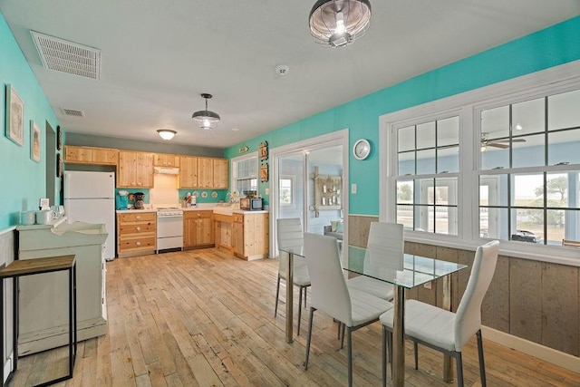 kitchen featuring light countertops, visible vents, stove, light wood-style floors, and freestanding refrigerator