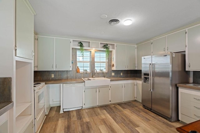 kitchen featuring white appliances, a sink, visible vents, and white cabinetry