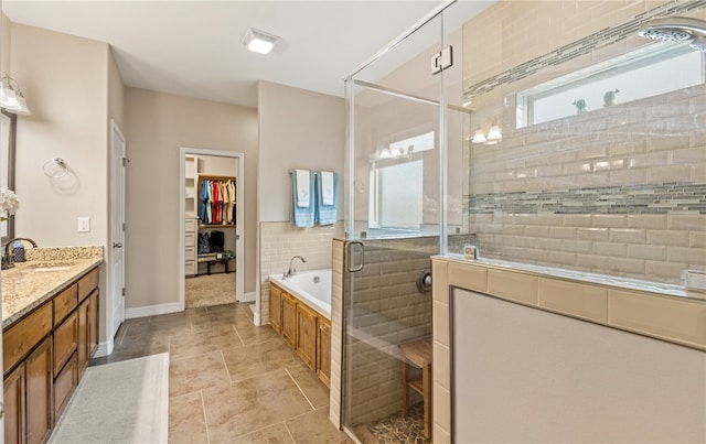 7622 Neches Dr, Corpus Christi, TX 78414 - bathroom featuring a shower stall, a garden tub, vanity, a spacious closet, and tile patterned flooring