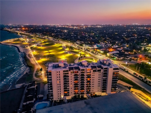 aerial view at dusk featuring a water view