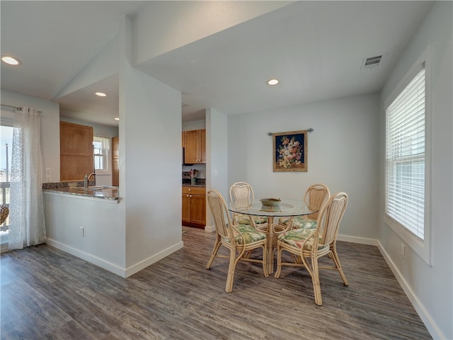 dining space featuring dark hardwood / wood-style floors, sink, and lofted ceiling