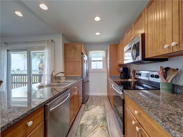 kitchen featuring plenty of natural light, sink, light hardwood / wood-style flooring, and appliances with stainless steel finishes