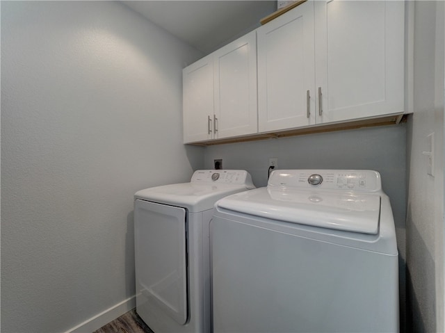 clothes washing area with cabinets, separate washer and dryer, and dark hardwood / wood-style floors