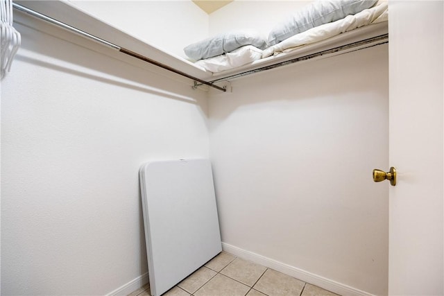 walk in closet with light tile patterned floors