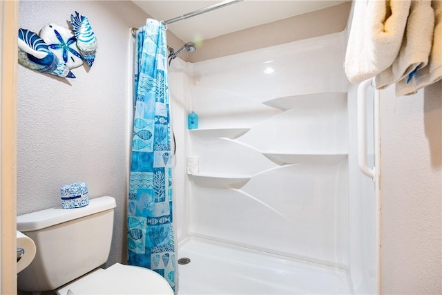 bathroom featuring a shower with shower curtain and toilet