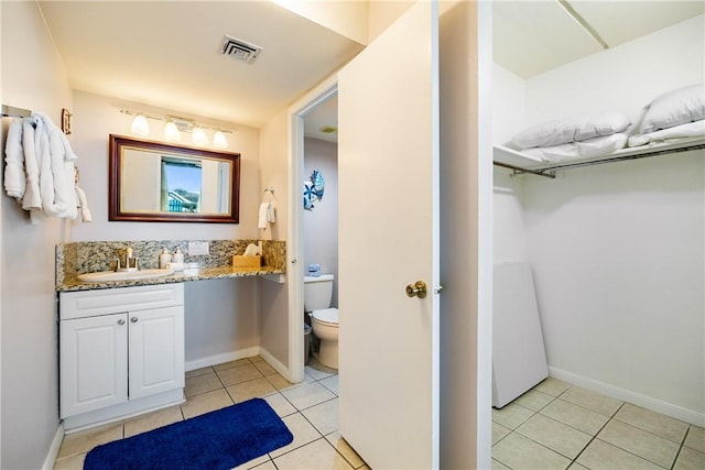 bathroom featuring tile patterned floors, vanity, and toilet