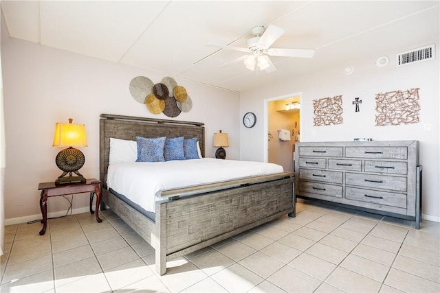 bedroom with ceiling fan, light tile patterned flooring, and ensuite bathroom